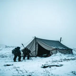Search team discovering abandoned tent half-buried in snow, fog rising, cinematic 8k.